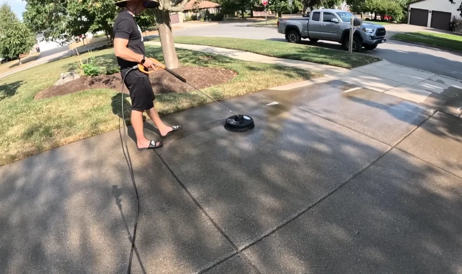 Professional technician safely pressure washing concrete driveway in Bradenton FL